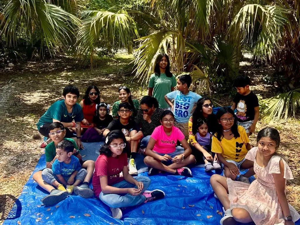 Children gathered on a picnic tarp at the Odia picnic
